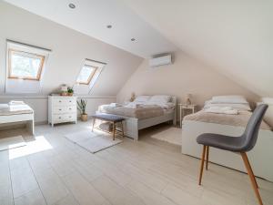 una camera mansardata con 2 letti e una sedia di Salix Guesthouse by Mital a Szeged