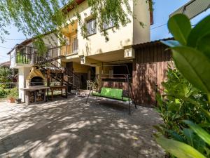 una casa con una panchina verde nel cortile di Salix Guesthouse by Mital a Szeged