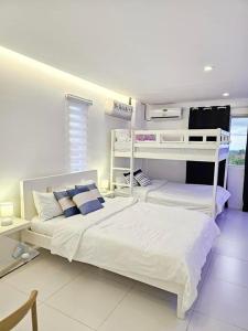 a bedroom with two bunk beds and a desk at Casa Rama Hotel Tagaytay in Tagaytay