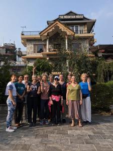 un gruppo di persone che si trovano di fronte a un edificio di The Mountain House a Pokhara