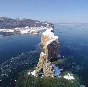 an island in the ocean with a large rock in the water at Mining Rooms Gaspé Murdochville in Gaspé