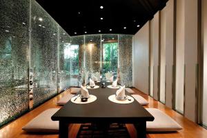 a dining room with a table with chairs and glass walls at Hilton Kuala Lumpur in Kuala Lumpur