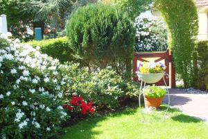 a garden with flowers and a basket of flowers at Ferienwohnungen im Klönhus in Prerow