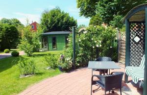 a patio with a table and chairs in a garden at Ferienwohnungen im Klönhus in Prerow