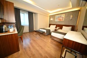 伊斯坦布尔Sogut Hotel Old City的一间有两张床和厨房的酒店房间