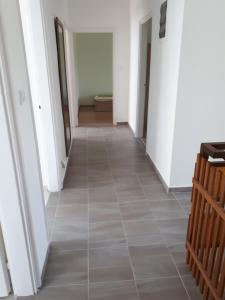 a hallway with white walls and a tile floor at Napsugár apartman Balatonboglár in Balatonboglár