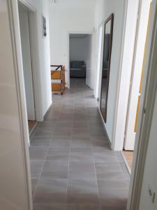 a hallway with white walls and a tile floor at Napsugár apartman Balatonboglár in Balatonboglár