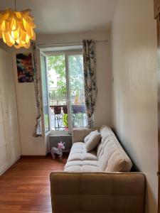 a couch in a living room with a window at Beautiful 3-room, Porte Saint-Cloud, Paris in Paris +1 photo