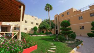 a courtyard of a building with a tree and flowers at Boudl Al Malaz - بودل الملز in Riyadh +45 photos