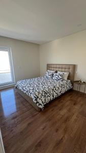 ein Schlafzimmer mit einem Bett und einem Holzboden in der Unterkunft Vila Mar Guest House in Vila do Conde