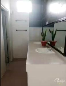 LiloanGarden INN的一间白色浴室，配有洗手池和镜子。 更多4张照片