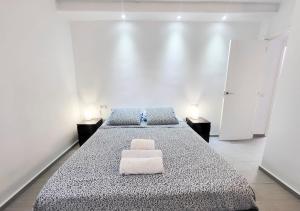 ein weißes Zimmer mit 2 Betten und 2 Lampen in der Unterkunft flower apartment in Playa de las Americas