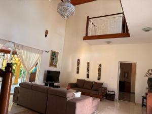 a living room with a couch and a tv at Villa Arcadia in Nosy Be