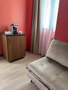 a living room with a couch and a coffee maker at Hôtel du Commerce-restaurant au Couteau in Nogent