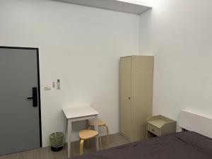 a bedroom with a bed and a desk and a cabinet at 雅居旅店 in Puli +2 photos