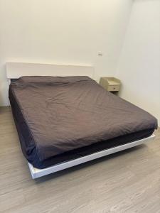 a bed with a brown blanket on top of it at 雅居旅店 in Puli