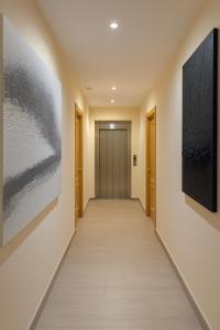a hallway with two paintings on the wall and a hallway sidx sidx sidx at Hotel Ancla in Oropesa del Mar +13 photos