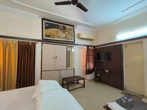a hotel room with a bed and a tv and a room at Hotel City Palace in Rānchī