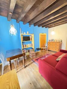 a living room with a red couch and a piano at Casa Torrazzo in Pisogne