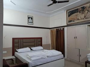 a bedroom with a bed with white sheets and a ceiling at Hotel City Palace in Rānchī