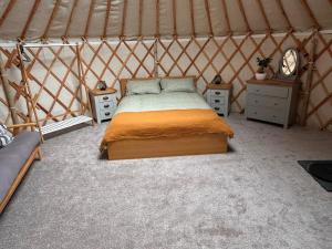 a bedroom with a bed in a yurt at Bracken Barns Glamping & Massage in Minishant