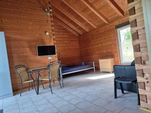 a room with a table and chairs and a tv at Vakantie boerderij Pepinushof - Blokhut in Maria-Hoop