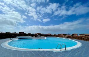 a large swimming pool with a blue sky in the background at El Nido del Sol in La Oliva