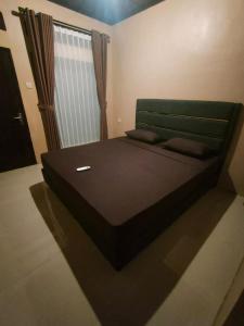 a large bed in a room with a window at Lia Homestay Ekas Bay in Pulau Gilkaliantan