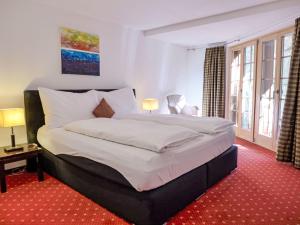 a bedroom with a large bed with white sheets at Apartment Chalet Smaragd-3 by Interhome in Grindelwald