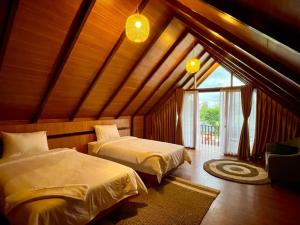 a bedroom with two beds and a window at Vany Villa Balige in Balige