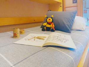 een boek op een bed met een teddybeer en een speeltje bij Studio La pointe des Aravis 3 by Interhome in Saint-Gervais-les-Bains