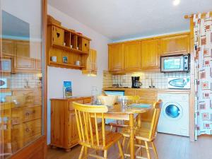 een keuken met een tafel en stoelen en een vaatwasser bij Studio La pointe des Aravis 3 by Interhome in Saint-Gervais-les-Bains