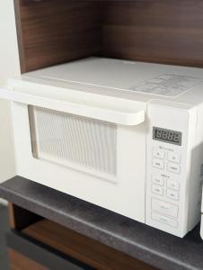 - un four micro-ondes blanc installé au-dessus d'une étagère dans l'établissement 縁 yukari, à Takamatsu