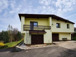 a yellow house with a balcony and a driveway at Holiday Home Jesenný by Interhome in Jesenný