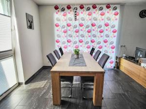 tavolo da pranzo con sedie e parete con fiori di Apartment Tschiderer by Interhome a See