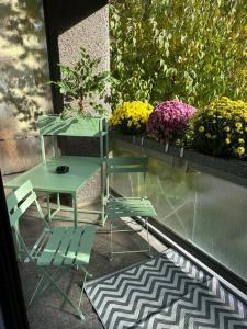 d'une table et d'une chaise sur un balcon fleuri dans l'établissement Ferdinands Gateaway inkl Breakfast, à Berne