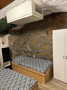 Pokój z 2 łóżkami i kamienną ścianą w obiekcie Suterénní byt na Hejtmánce v Mladé Boleslavi u letiště w mieście Mladá Boleslav +10 zdjęć