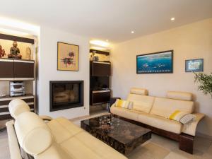 a living room with a couch and a fireplace at Holiday Home Ty Pors Ar Pagn by Interhome in Penmarcʼh
