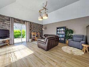 a living room with a couch and a tv at Holiday Home Orphée by Interhome in Telgruc-sur-Mer