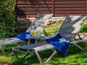 deux chaises de jardin avec des verres de jus d'orange dessus dans l'établissement Apartment Jurkovic-2 by Interhome, à Njivice