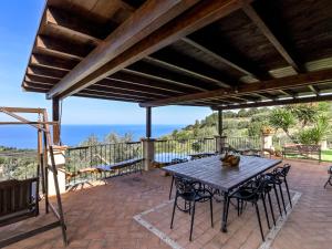 Un patio con mesa y sillas y el mar. en Villa Ricali by Interhome, en Porto Santo Stefano