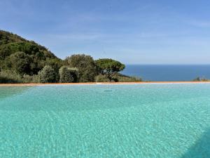 Una gran piscina de agua turquesa junto a una playa. en Villa Ricali by Interhome, en Porto Santo Stefano 74 fotos más
