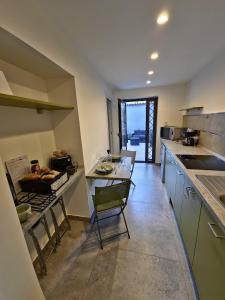 Una cocina con encimera, mesa y sillas. en Le Gioie di Monica Casa Vacanze per Pompei, en Boscotrecase