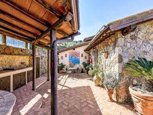 an outdoor patio with potted plants and a stone wall at Villa Ricali by Interhome in Porto Santo Stefano +74 photos