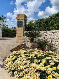una torre dell'orologio con un mazzo di fiori gialli di ARIA D'ORIENTE a Uggiano la Chiesa