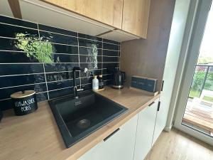 Una cocina con un fregadero negro y una ventana. en Enduro Spot - Apartament pod Kozią Górą, en Bielsko-Biala 38 fotos más