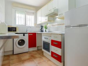 a kitchen with red cabinets and a washer and dryer at Holiday Home Zona Estival-3 by Interhome in Salou