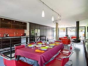 a dining room with a table and red chairs at Holiday Home Villa de la Baie by Interhome in Locquirec