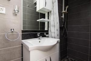 Studio Scala in a seaside house في دوبروتا: حمام مع حوض أبيض ومرآة