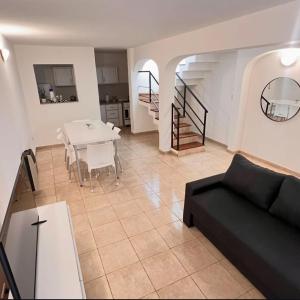 a living room with a black couch and a table at Dorrego Departamentos in Villa Dolores